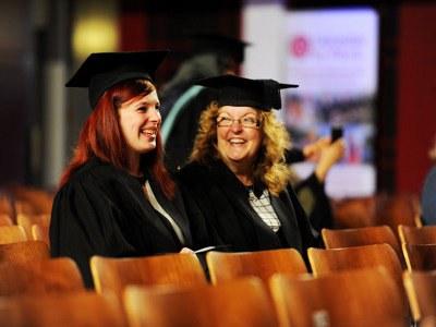 2 graduates smiling