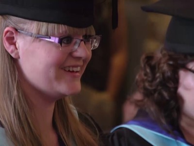 2 graduates smiling