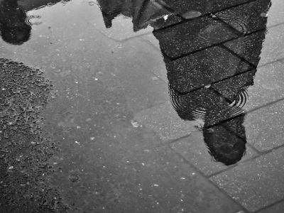 reflection of person in puddle