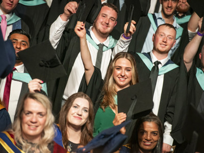 group shot of graduates raising caps