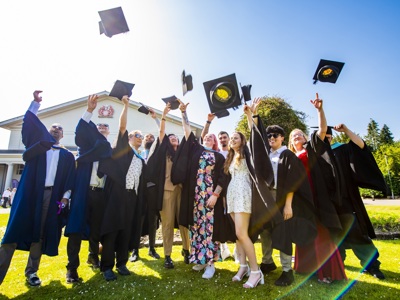 Group of graduates throwing hats in the air