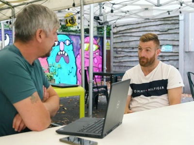 2 people behind desk with laptop