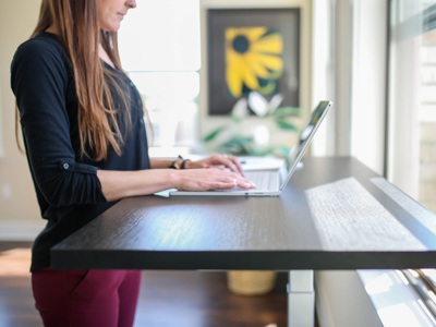person typing at standing desk