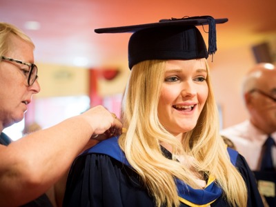 fitting gown on graduate